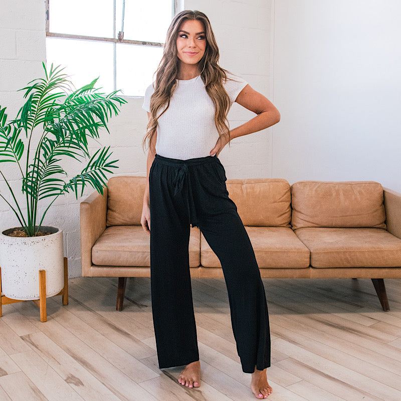 Sydne Style shows how to wear a bathing suit off the beach with black flowy  pants | Sydne Style